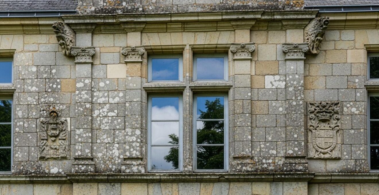 Façade en pierre d'un manoir historique typique du Val de Loire sous un ciel clair